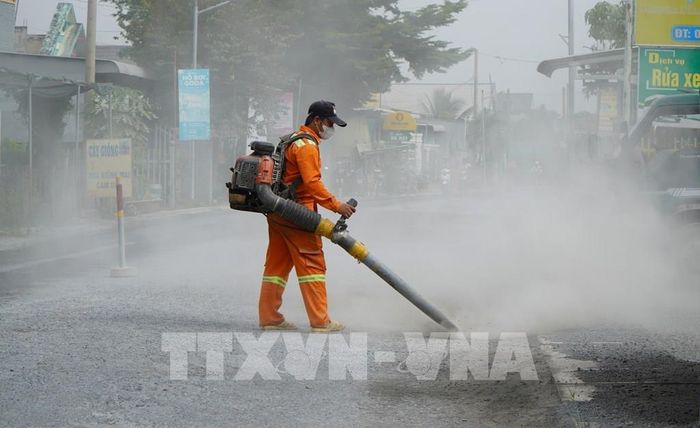 Công nhân vệ sinh mặt đường, chuẩn bị thảm nhựa Quốc lộ 30, đoạn qua ấp Gò Da, xã Tân Hồng (thuộc Dự án sửa chữa Quốc lộ 30). Ảnh: Nhựt An - TTXVN
