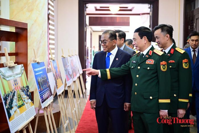 Bộ trưởng Quốc phòng hai nước xem trưng bày ảnh về quan hệ hợp tác quốc phòng hai bên.