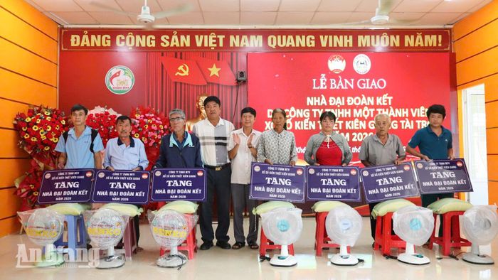 Lãnh đạo xã Khánh Bình trao bảng tượng trưng tặng nhà Đại đoàn kết cho người dân.