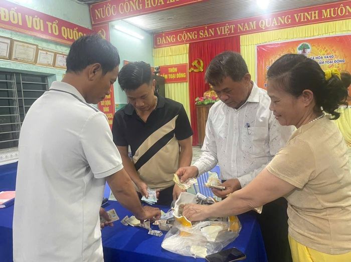 Cán bộ, đảng viên xã Hòa Vang đập heo đất tiết kiệm, gây quỹ hỗ trợ sinh kế cho hộ nghèo, hộ cận nghèo. Ảnh: ĐVCC