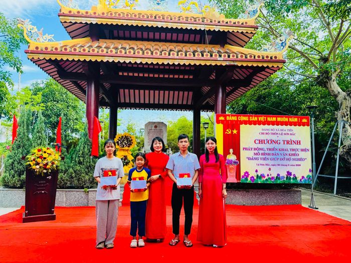 Lãnh đạo xã Hòa Tiến tặng quà cho học sinh có hoàn cảnh khó khăn trong khuôn khổ triển khai mô hình “Đảng viên giúp đỡ hộ nghèo”. Ảnh do đơn vị cung cấp