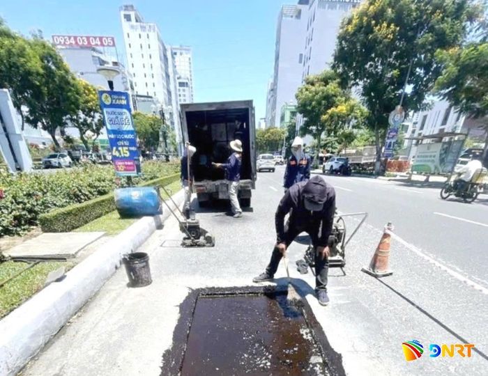 Công nhân Công ty CP Cầu đường Đà Nẵng khắc phục hư hỏng mặt đường Võ Văn Kiệt, đoạn thuộc địa phận phường An Hải. Ảnh: HẢI TRẦN
