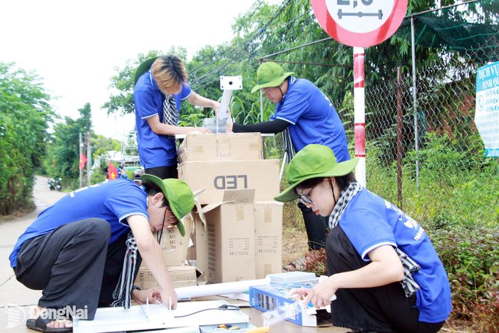 Sinh viên tình nguyện Trường đại học Công nghệ Miền Đông lắp đặt đèn năng lượng mặt trời tại ấp Phú Vinh, xã Phú Vinh.
