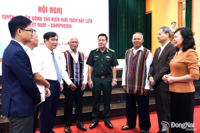 Lãnh đạo Ban Tuyên giáo Trung ương, Thành ủy Đồng Nai và các đại biểu trao đổi với già làng, người có uy tín bên lề hội nghị. Ảnh: Nguyệt Hà
