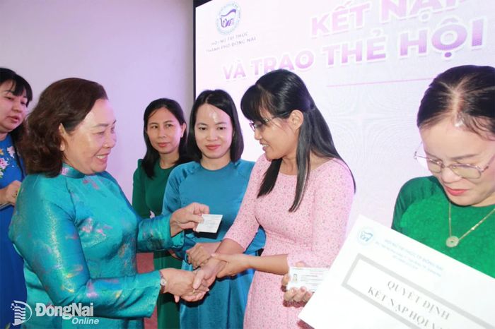 Tiến sĩ Nguyễn Thị Thu Lan, Chủ tịch Hội Nữ trí thức thành phố trao thẻ hội viên cho hội viên mới. Ảnh: Nga Sơn