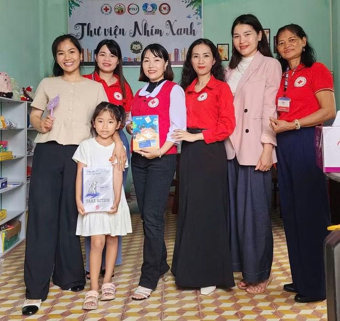  Chị Mai Thị Ngọc Ánh (thứ 4 từ phải sang) cùng các thành viên Câu lạc bộ Tình nguyện viên Chữ thập đỏ Kbang thành lập Thư viện Nhím Xanh. Ảnh: M.N 
