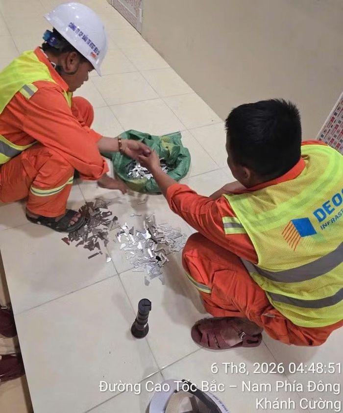  Lực lượng chức năng thu gom mảnh kim loại rơi vãi trên mặt đường cao tốc. Ảnh: Đại Thắng 