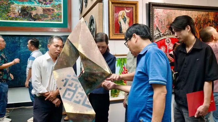 Khách tham quan tìm hiểu các tác phẩm trưng bày tại triển lãm. Ảnh: H.V