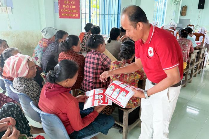 Phát tờ rơi cho người dân tại buổi truyền thông