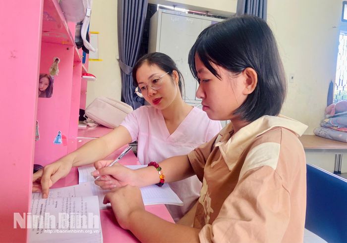 Chị Đỗ Thị Mỹ Lệ hướng dẫn cháu Chu Ngọc Anh làm bài tập.