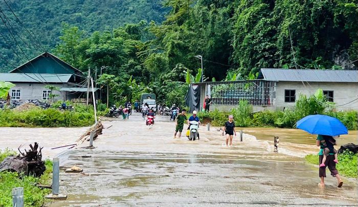 Công an xã Minh Ngọc hỗ trợ người dân qua khu vực cầu đập tràn. (Ảnh:CATQ)