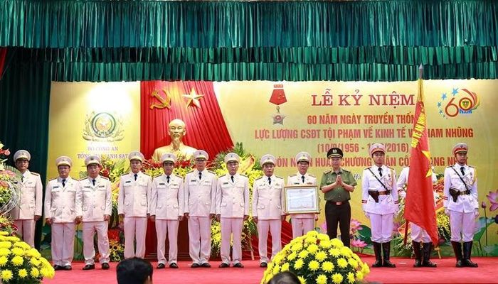  Thừa ủy quyền của Chủ tịch nước, Bộ trưởng Tô Lâm gắn Huân chương Quân công hạng Nhất lên lá cờ truyền thống của lực lượng Cảnh sát điều tra tội phạm về kinh tế và tham nhũng. (Ảnh tư liệu ngày 10/8/2016) 