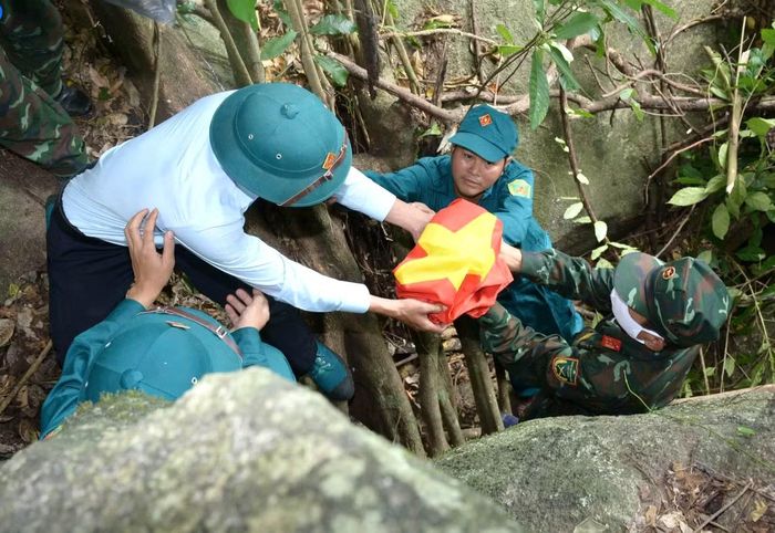 Chính quyền địa phương cùng cán bộ, chiến sĩ Đội K51 tiến hành đưa hài cốt liệt sĩ ra khỏi hang đá (Ảnh Đội K51).