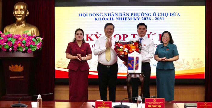 Lãnh đạo phường Ô Chợ Dừa tặng hoa chúc mừng đồng chí Lê Tuấn Định. Ảnh: Võ Giang