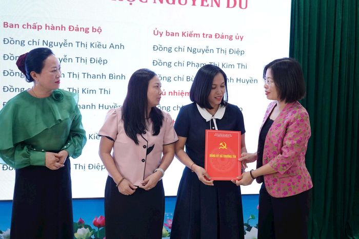 Đồng chí Trần Hồng Hạnh - Phó Bí thư Thường trực Đảng ủy phụ trách Đảng bộ xã Thường Tín trao quyết định thành lập Đảng bộ cho lãnh đạo các trường học trên địa bàn sáng 6-8. Ảnh: PV