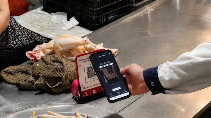Khách hàng quét mã QR tại chợ La Cả. Ảnh Thu Oanh