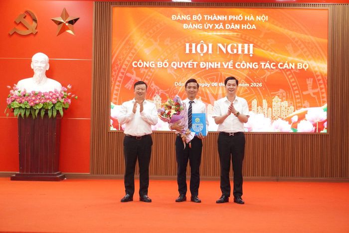 Lãnh đạo xã Dân Hòa trao quyết định, tặng hoa chúc mừng đồng chí Nguyễn Thành Luân - Tân Chánh Văn phòng HĐND - UBND xã. Ảnh: Lê Dung.