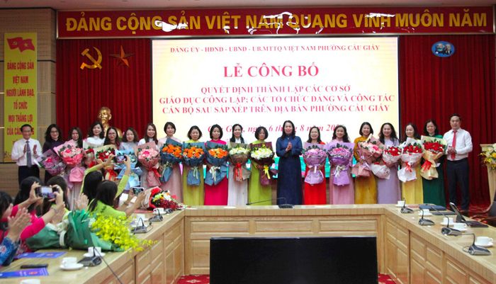 Lãnh đạo phường Cầu Giấy trao tặng những lẵng hoa tươi thắm đến các nhà giáo thôi giữ chức vụ quản lý sau sáp nhập. Ảnh: Vân Nhi