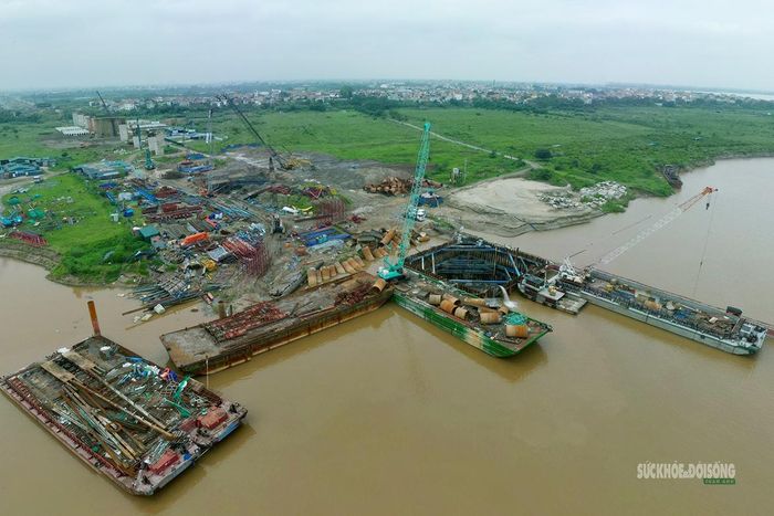 Nhiều phương tiện tập trung thi công sát mép sông. Ảnh: T. Anh
