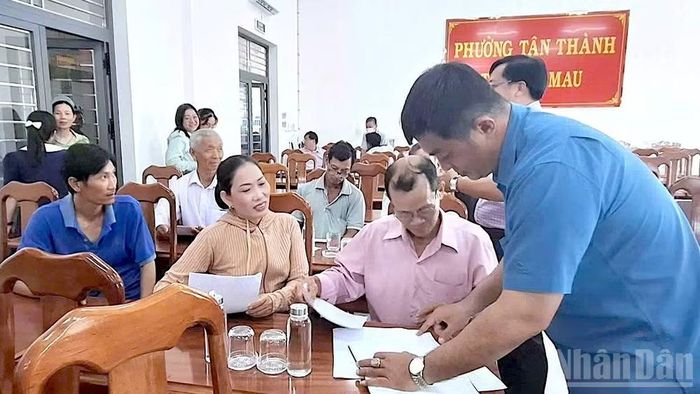 Người dân ký xác nhận đồng ý phương án hỗ trợ thiệt hại do chính quyền phường Tân Thành (tỉnh Cà Mau) công bố. (Ảnh: HỮU TÙNG).