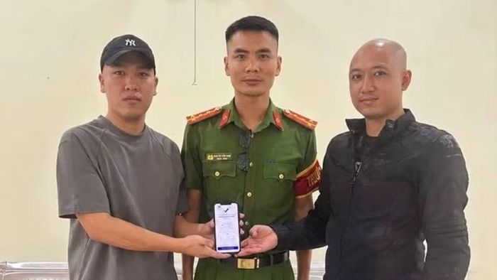 Anh Hoàng Quốc Cường (bên trái) trả lại 5 tỷ đồng chuyển khoản nhầm cho anh Quân trước sự chứng kiến của đại diện Công an xã Hoàn Lão. (Ảnh: Công an xã Hoàn Lão)
