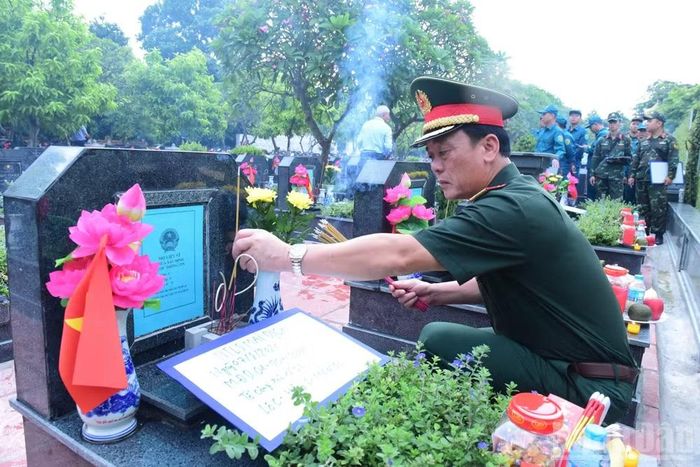 Thiếu tướng Đào Văn Nhận, Ủy viên Ban Thường vụ Thành ủy, Tư lệnh Bộ Tư lệnh Thủ đô Hà Nội thành kính thắp hương trên các phần mộ liệt sĩ chưa xác định danh tính. (Ảnh: HỮU THU)