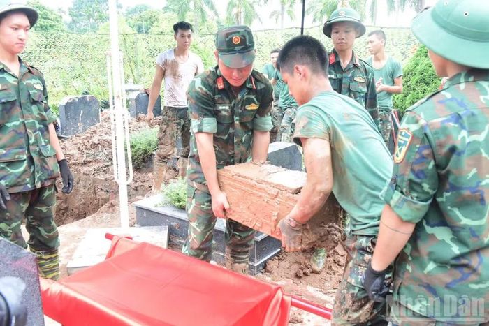 Hài cốt liệt sĩ chưa xác định danh tính tại Nghĩa trang Mai Dịch (phường Phú Diễn) được cán bộ, chiến sĩ vận chuyển đến khu lấy mẫu. (Ảnh: HỮU THU)