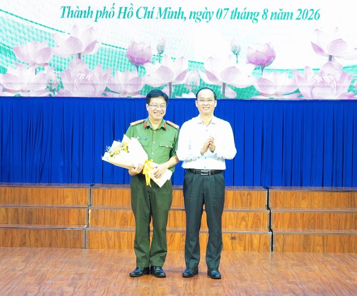 Đồng chí Nguyễn Khoa Hải, đại diện đơn vị cụm trưởng tặng hoa đến báo cáo viên - Thượng tá Đoàn Minh Hòa. Ảnh: PHƯƠNG UYÊN