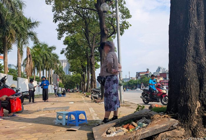  Một "phe vé" đứng chờ khách. Ảnh: ĐỖ TRUNG 