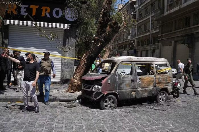 Chiếc xe bị hư hại sau hai vụ nổ làm rung chuyển khu vực ở Damascus, Syria, hồi tháng 7/2026. Ảnh: AP/Omar Albam.