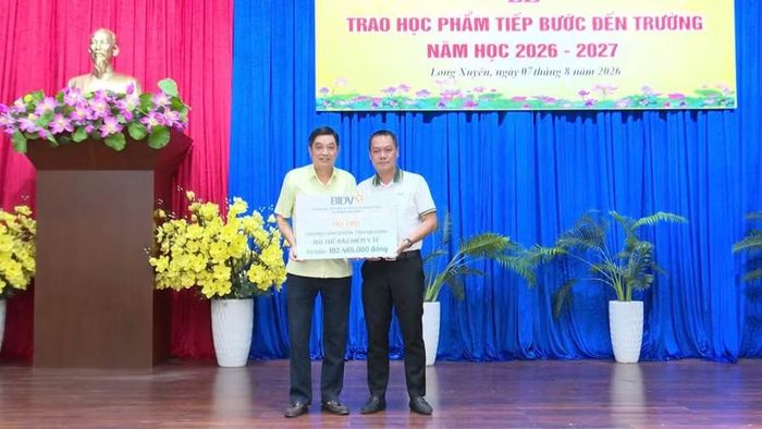 Đại diện Ngân hàng TMCP Đầu tư và Phát triển Việt Nam (BIDV) Chi nhánh An Giang trao bảng tượng trưng hỗ trợ địa phương 150 thẻ BHYT cho học sinh khó khăn.