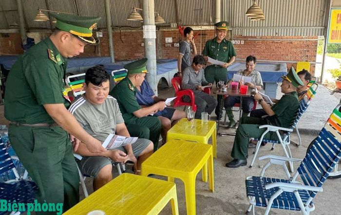 Cán bộ Đồn Biên phòng Vàm Trảng Trâu tuyên truyền, phát tờ rơi và hướng dẫn cách sử dụng hòm thư ẩn danh chống xuất, nhập cảnh trái phép tại các hộ dân trên địa bàn. Ảnh: Đinh Quân