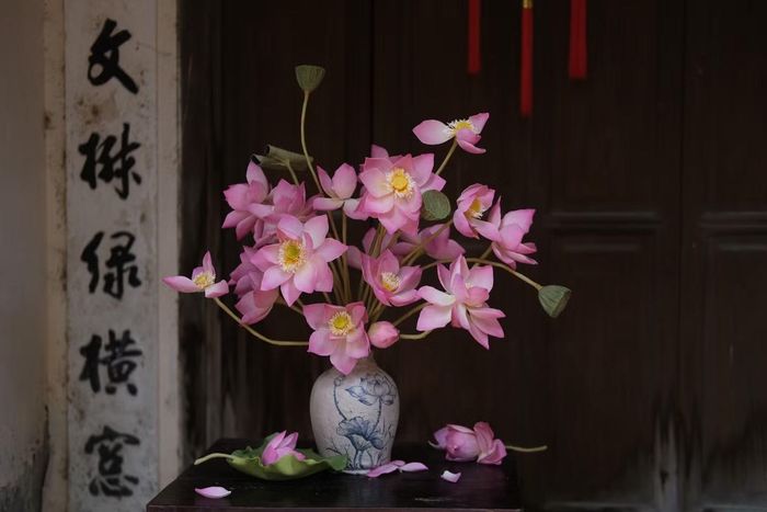 Mỗi dịp Trung thu, Nguyễn Thị Thùy Dương (31 tuổi, Hà Nội) lại dành thời gian sáng tạo những mẫu bánh mới từ chất liệu truyền thống. Năm nay, cô cùng các cộng sự gây bất ngờ khi làm 3 chiếc bánh Trung thu hình bình hoa với kích thước gần như thật, kết hợp giữa bánh nướng và nghệ thuật nặn tò he.