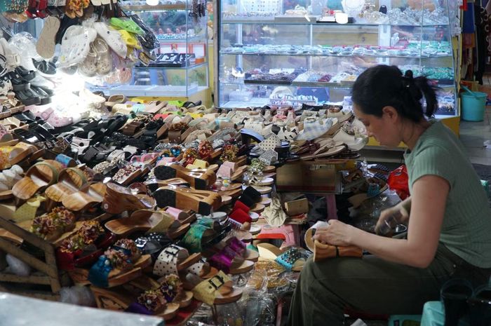 Chị Mai Thanh - thế hệ thứ hai tiếp nối nghề đóng guốc mộc của gia đình tại chợ Tân Định. Ảnh: Anh Nhàn