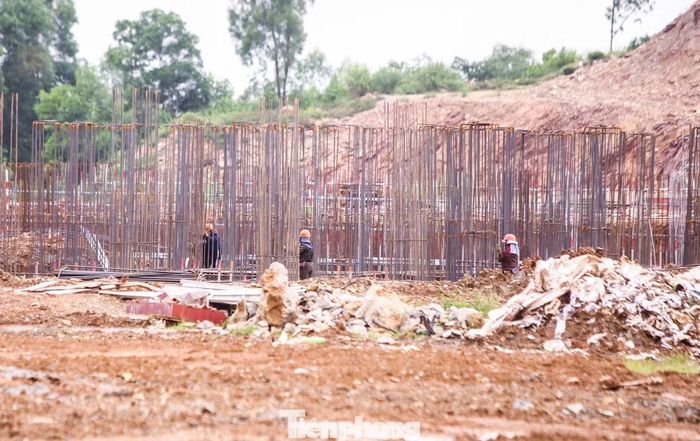 Tại công trường, công nhân và máy móc vẫn đang thi công phần nền móng. Phần lớn diện tích dự án vẫn là bãi đất trống, vật liệu và thiết bị nằm ngổn ngang. Với khối lượng công việc còn lại, dự án đứng trước áp lực lớn, khó có thể hoàn thành theo tiến độ đề ra.