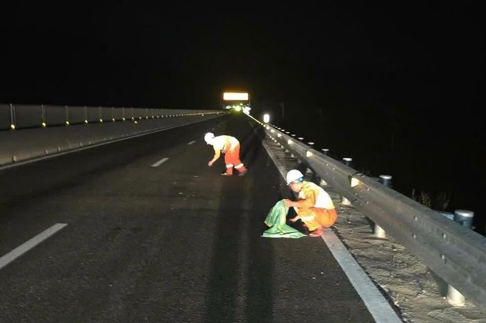 Công nhân thu dọn các vụn sắt trên cao tốc.