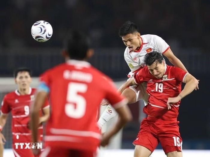 Indonesia (áo đỏ) đang bất lợi sau trận thua Việt Nam. (Ảnh: TTXVN phát)