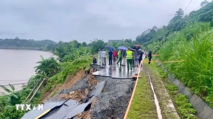 Theo ghi nhận tại hiện trường, toàn bộ phần mặt đường dài khoảng 30 mét đã bị đứt gãy, sạt trượt hoàn toàn xuống phía ta luy âm, giáp bờ sông Hồng. (Ảnh: TTXVN phát)
