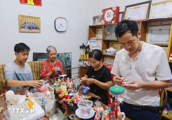 Gia đình ba thế hệ nhà nghệ nhân Đặng Văn Hậu tiếp truyền nghề truyền thống "Tò he". (Ảnh: Khánh Hòa/TTXVN)