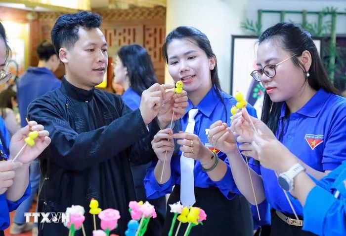 Nghệ nhân Đặng Văn Hậu hướng dẫn các đoàn viên thanh niên trải nghiệm làm tò he tại chương trình “Tự hào truyền thống 95 năm - Tuổi trẻ lan tỏa giá trị văn hóa dân tộc.” (Ảnh: Khánh Hòa/TTXVN)