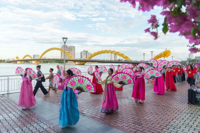Màn múa quạt tập thể uyển chuyển, thướt tha của các nữ sinh viên bên cạnh dòng sông Hàn thơ mộng. (Ảnh: Thanh Phong/Vietnam+)