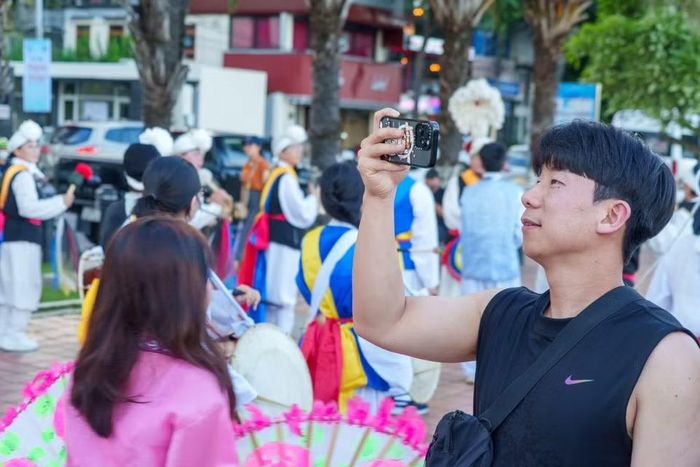 Vẻ đẹp đa sắc màu của buổi diễu hành khiến nhiều du khách và người dân thích thú dùng điện thoại ghi lại. (Ảnh: Thanh Phong/Vietnam+)