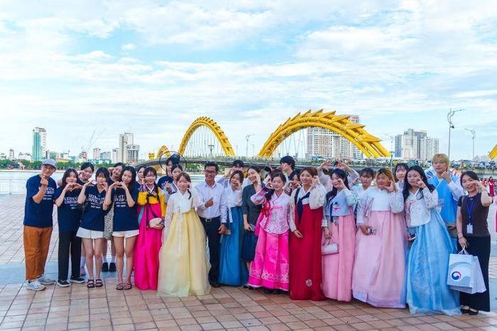 Các thành viên đoàn diễu hành chụp ảnh lưu niệm tại khu vực cầu Rồng. (Ảnh: Thanh Phong/Vietnam+) 