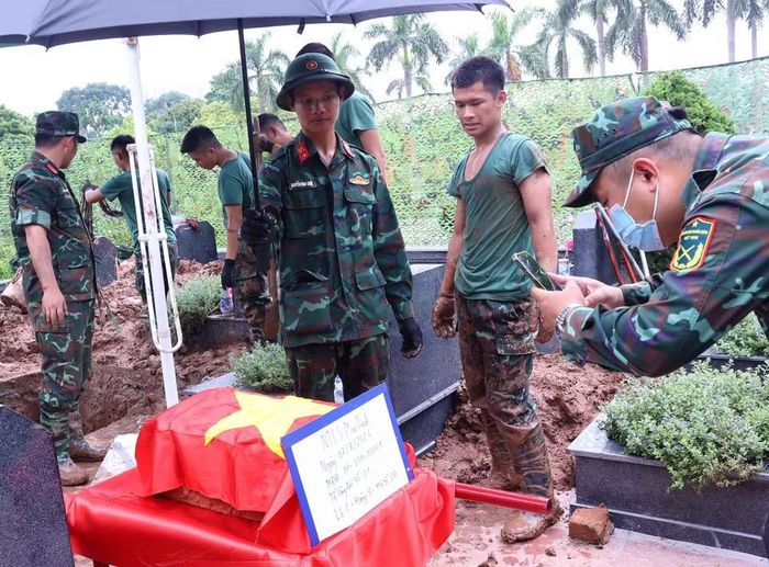 Thực hiện nghi thức phủ Quốc kỳ trang trọng, tri ân Anh hùng liệt sỹ đã hy sinh vì độc lập, tự do của Tổ quốc tại Nghĩa trang Mai Dịch (phường Phú Diễn). (Ảnh: Văn Điệp/TTXVN)