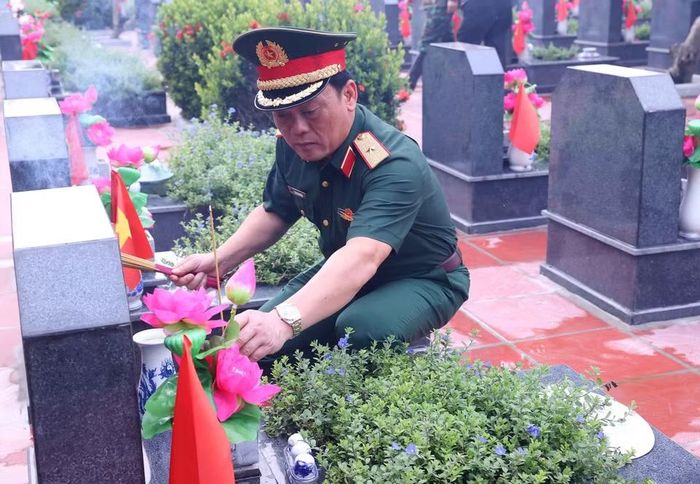 Thiếu tướng Đào Văn Nhận, Tư lệnh Bộ Tư lệnh Thủ đô Hà Nội thắp hương trên phần mộ liệt sỹ tại Nghĩa trang Mai Dịch (phường Phú Diễn). (Ảnh: Văn Điệp/TTXVN)