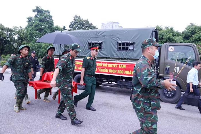 Khai quật, đưa hài cốt liệt sỹ chưa xác định danh tính về khu vực lấy mẫu sinh phẩm tại Nghĩa trang Mai Dịch (phường Phú Diễn). (Ảnh: Văn Điệp/TTXVN) 