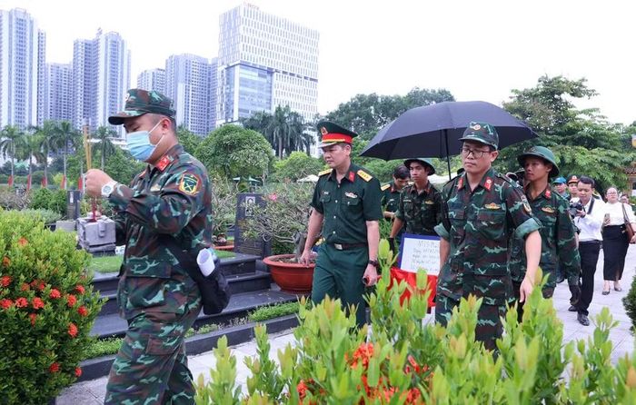 Khai quật, đưa hài cốt liệt sỹ chưa xác định danh tính về khu vực lấy mẫu sinh phẩm tại Nghĩa trang Mai Dịch (phường Phú Diễn). (Ảnh: Văn Điệp/TTXVN)