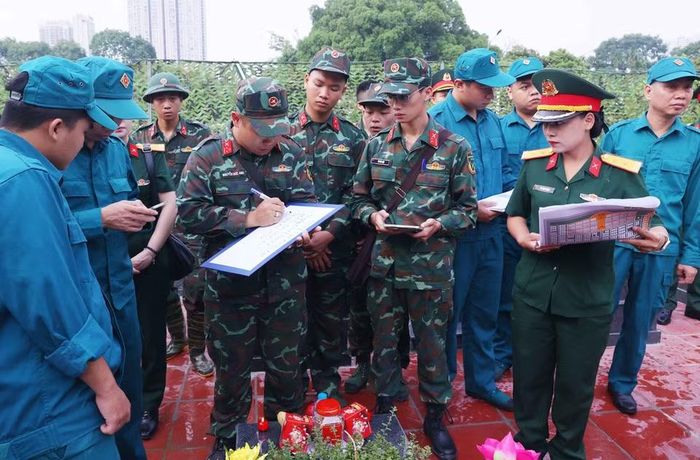 Việc mã hóa các phần mộ được thực hiện cẩn thận trước khi tiến hành khai quật lấy mẫu sinh phẩm tại Nghĩa trang Mai Dịch (phường Phú Diễn). (Ảnh: Văn Điệp/TTXVN)