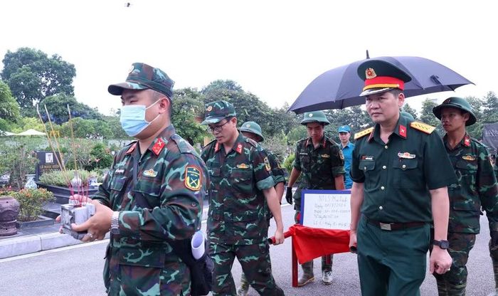Khai quật, đưa hài cốt liệt sỹ chưa xác định danh tính về khu vực lấy mẫu sinh phẩm tại Nghĩa trang Mai Dịch (phường Phú Diễn). (Ảnh: Văn Điệp/TTXVN)