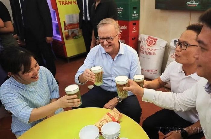 Thủ tướng Australia Anthony Albanese thưởng thức món bánh mỳ patê truyền thống, uống bia hơi Hà Nội tại một quán ăn trên phố Đường Thành, quận Hoàn Kiếm, Hà Nội. (Ảnh: Lâm Khánh/TTXVN)